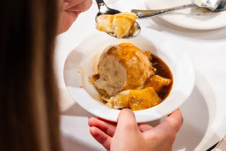 Person eating mashed potatoes and gravy at a restaurant.