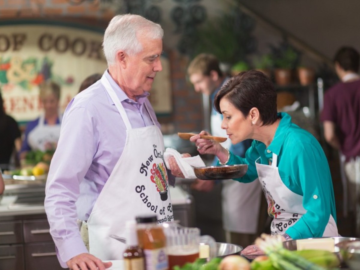 a man and woman preparing food on a table
