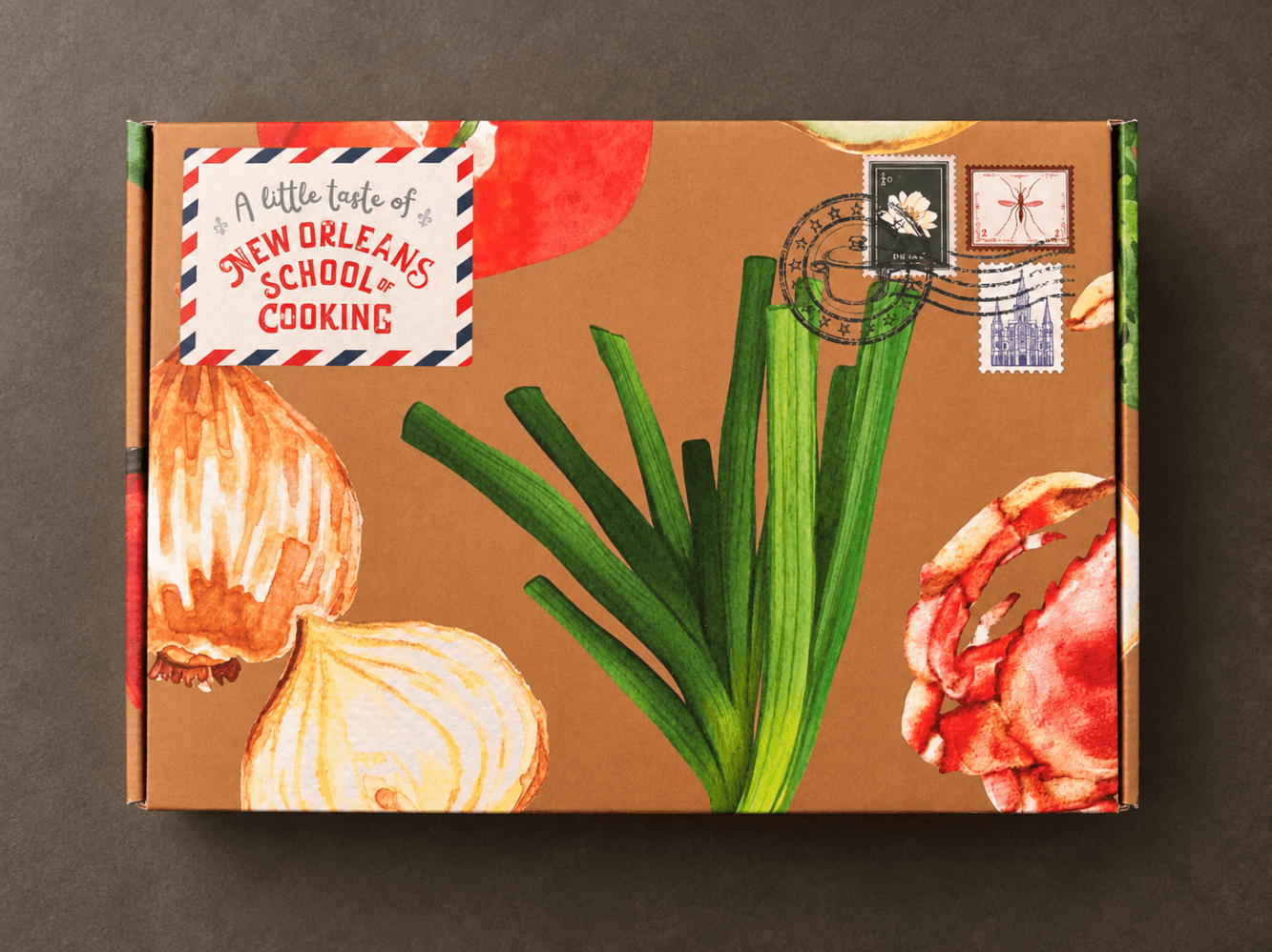 Colorful cooking-themed box with vegetables and New Orleans School of Cooking logo.