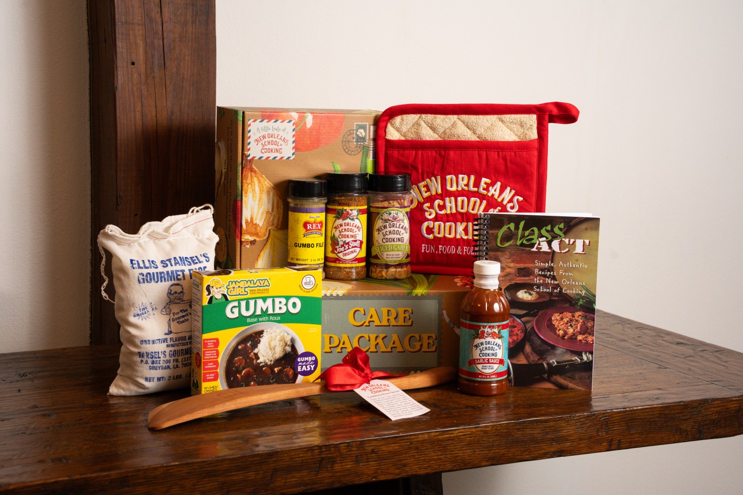 Assortment of cooking items, spices, and New Orleans-themed products on a wooden table.